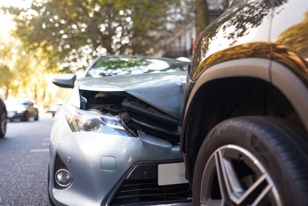 Front-end collision between two vehicles on a city street after a car accident.